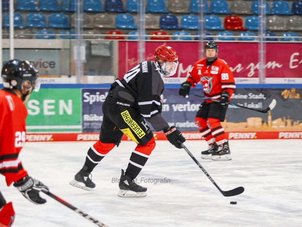 Eishockeyspieler der Firefighters und FireBugs im Spiel auf dem Eis.