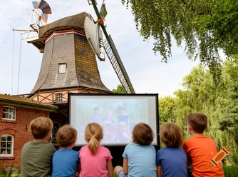 craiyon_160211_eine_realistische_szene__in_der_kinder__Ansicht_von_hinten__einen_kinofilm_schauen_und_die_auf_dem_R.png