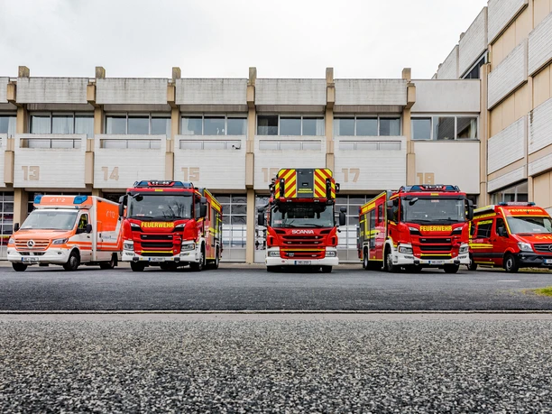 Mehrere Feuerwehrfahrzeuge stehen vor den nummerierten Toren der Fahrzeughalle.