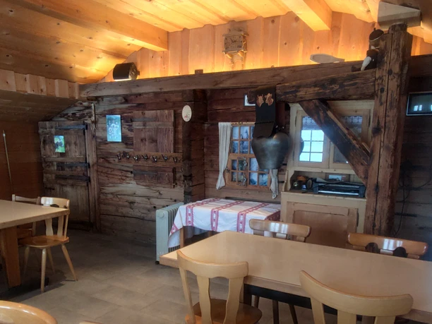 Stübli in alpine hut with tables and chairs