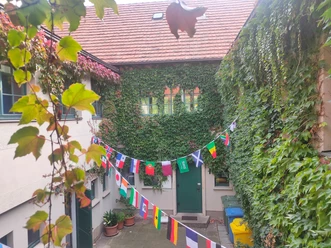 Haus auf der Mauer Blick in den mit Wimpeln geschmückten Innenhof des Haus auf der Mauer