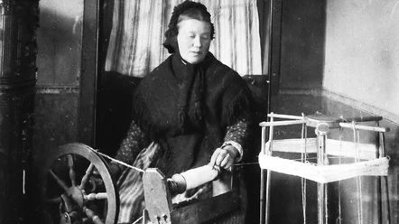 Leinenspinnen- traditionelle Heimarbeit Eine Frau spinnt Leinen an einem alten Spinnrad, umgeben von traditionellen Webutensilien.