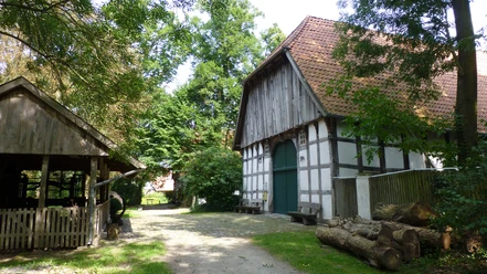 Das Holzhandwerksmuseum Historische Fachwerkscheune im Holzhandwerksmuseum mit umliegenden Bäumen und rustikalen Holzelementen.
