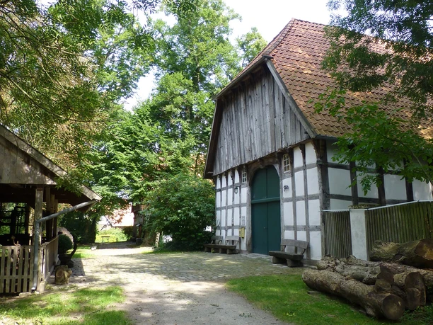 Das Holzhandwerksmuseum Historische Fachwerkscheune im Holzhandwerksmuseum mit umliegenden Bäumen und rustikalen Holzelementen.