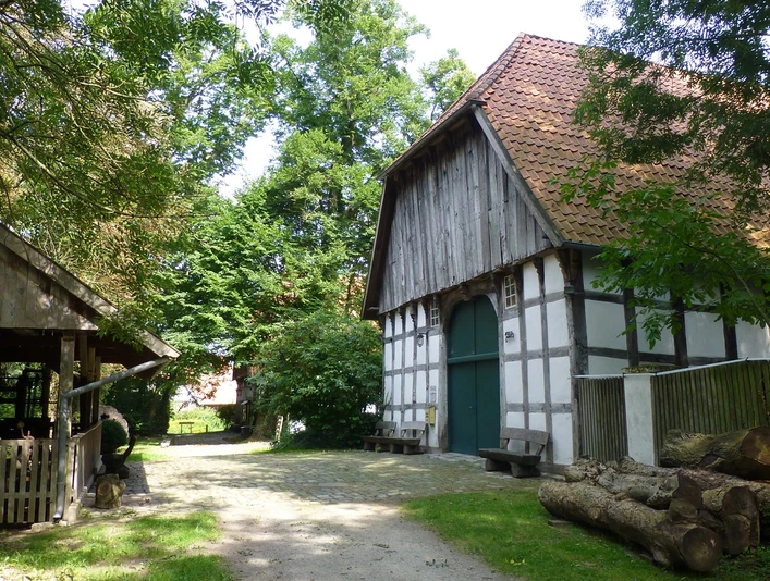 Das Holzhandwerksmuseum Historische Fachwerkscheune im Holzhandwerksmuseum mit umliegenden Bäumen und rustikalen Holzelementen.