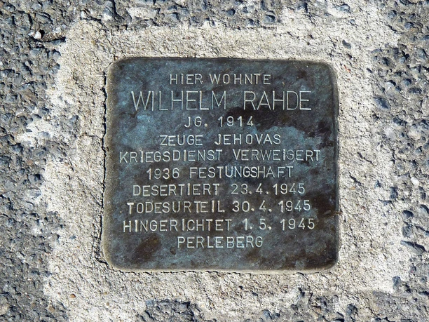 Das Wohnhaus Wilhelm Rahdes Gedenktafel aus Metall im Boden für Wilhelm Rahde, mit Informationen zu seinem Schicksal im Jahr 1945.