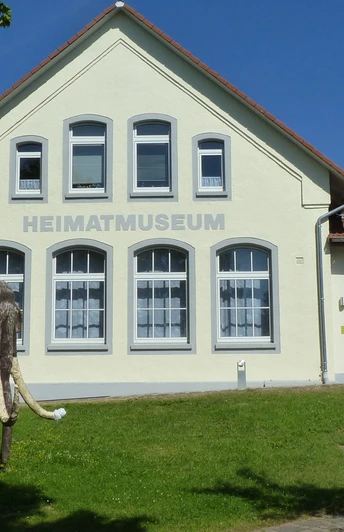 Das Heimatmuseum Löhne präsentiert ein historisches Gebäude mit einem Modell eines Mammuts davor.