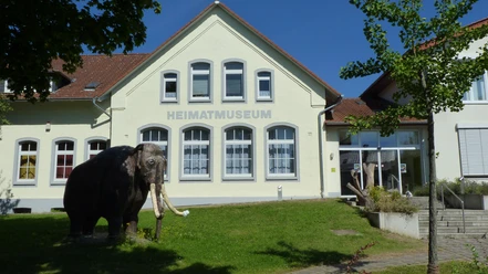 Heimatmuseum Löhne Das Heimatmuseum Löhne präsentiert ein historisches Gebäude mit einem Modell eines Mammuts davor.
