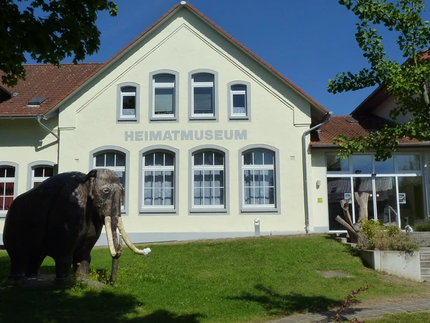 Heimatmuseum Löhne Das Heimatmuseum Löhne präsentiert ein historisches Gebäude mit einem Modell eines Mammuts davor.