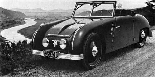 "neues" Automobil am alten Verkehrsweg "Weser" Historisches Auto auf einer gewundenen Straße entlang der Weser; umgeben von hügeliger Landschaft.