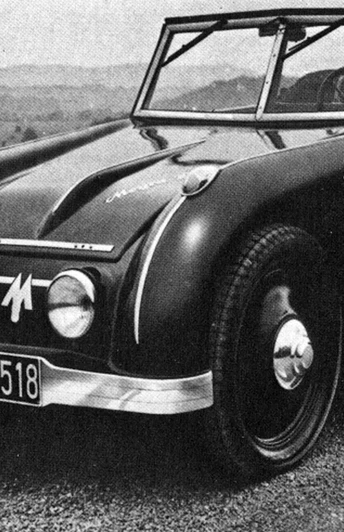 "neues" Automobil am alten Verkehrsweg "Weser" Historisches Auto auf einer gewundenen Straße entlang der Weser; umgeben von hügeliger Landschaft.