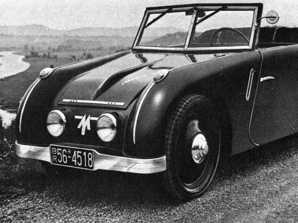 "neues" Automobil am alten Verkehrsweg "Weser" Historisches Auto auf einer gewundenen Straße entlang der Weser; umgeben von hügeliger Landschaft.