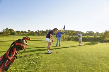 Weitblick Personen beim Putten auf sonnigem Golfplatz