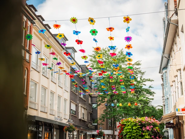 Mittlere Berliner Straße Farbenfrohe Blumendekoration über der Einkaufsstraße Mittlere Berliner Straße in Gütersloh.