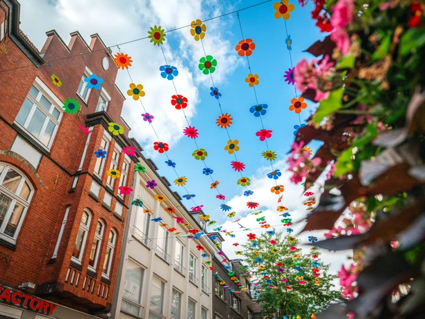 Mittlere Berliner Straße Bunte Blumen-Dekorationen über der Mittleren Berliner Straße in Gütersloh.