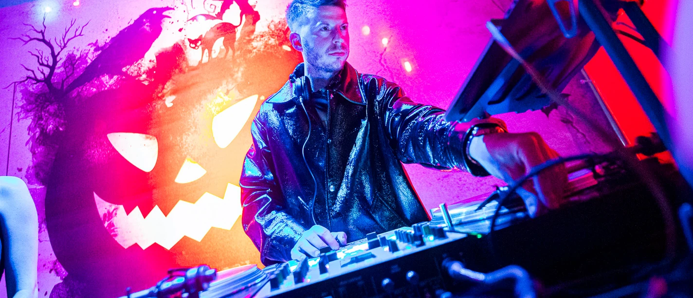 Hangoverween DJ am Pult, im Hintergrund Halloween-Dekoration