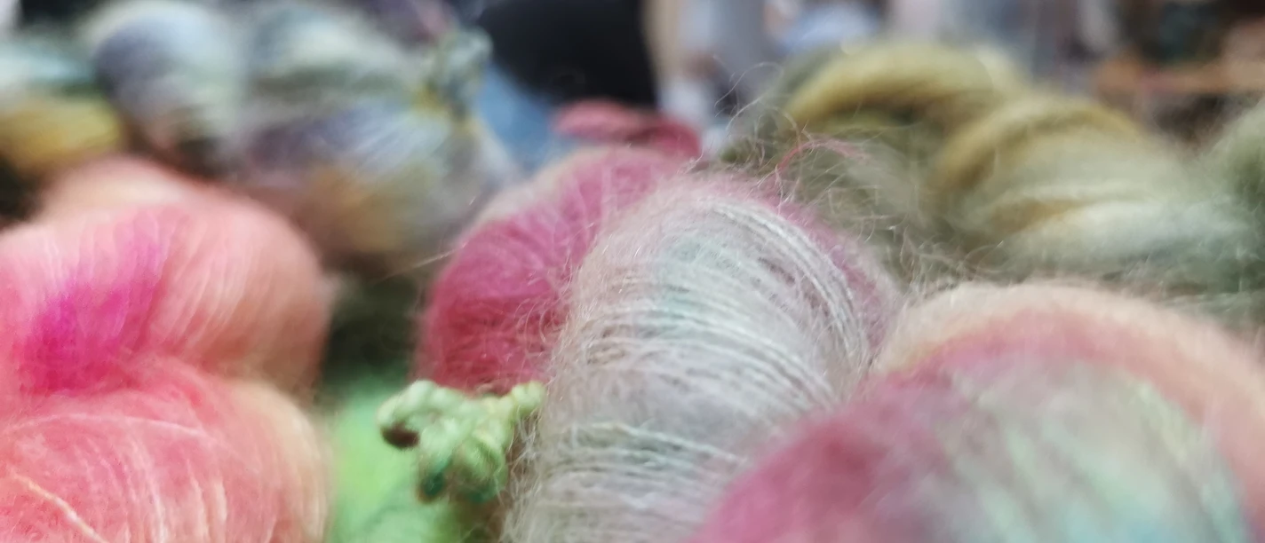Flauschige Wolle mit einem kleinen gefilztem Drachen der frech in die Welt schaut