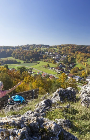 Am Alpinen Steig Ein Ehepaar auf dem Alpinen Steig macht Rast bei einer Ruhebank. Im Hintergrund hat meinen einen schönen Weitblick auf den Ort Schönhofen und die Juralandschaft.