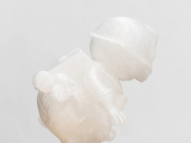 COLOAN - Thomas Baldischwyler Transparente Figurenskulptur auf hellem Holzsockel vor weißem Hintergrund