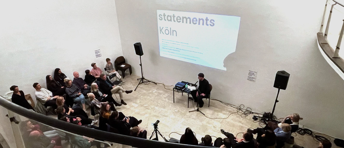 Audience at the "statements Köln" lecture series at the artothek, with a projection on the wall
