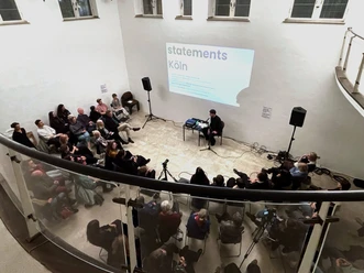 statements_Koeln_3.jpg Publikum bei der Vortragsreihe statements Köln in der artothek mit Projektion an der Wand