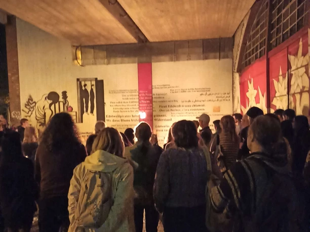 die de Muertos - Prozession am Edelweisspiraten Denkmal Menschenmenge bei nächtlicher Prozession vor beleuchteter Wandkunst unter einer Brücke