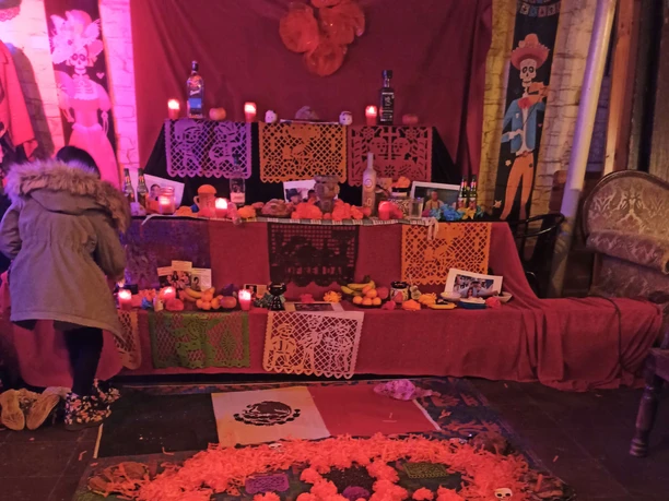 Schrein zum dia de Muertos Farbenreicher Totengedenk-Altar mit Kerzen, Blumen, Schädeln und Opfergaben