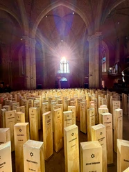 Spuren des Erinnerns Gedenkinstallation mit Holzstelen, Namen und Davidsternen unter Kirchengewölben.