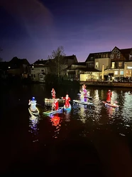 Beleuchtete SUP-Boards mit Weihnachtsfiguren auf der Aller bei Nacht. Beleuchtete SUP-Boards mit Weihnachtsfiguren auf der Aller bei Nacht.
