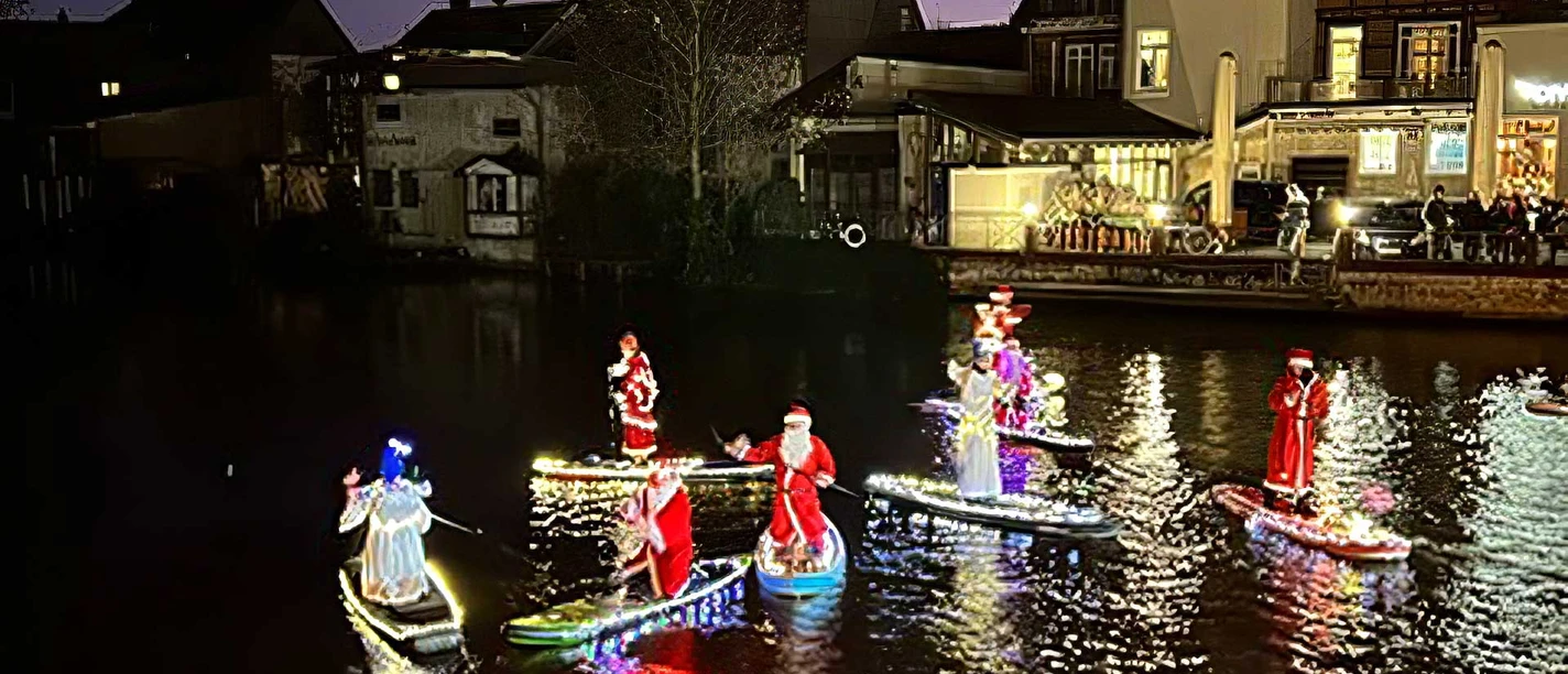 Beleuchtete SUP-Boards mit Weihnachtsfiguren auf der Aller bei Nacht. Beleuchtete SUP-Boards mit Weihnachtsfiguren auf der Aller bei Nacht.