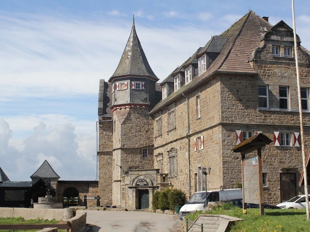 Burg Schwalenberg Burg Schwalenberg aus Stein mit markantem Turm und Fachwerk-Elementen, umgeben von Wolken.