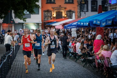 Läufer in Köln Läufer beim Halbmarathon auf Kopfsteinpflaster, Zuschauer am Streckenrand