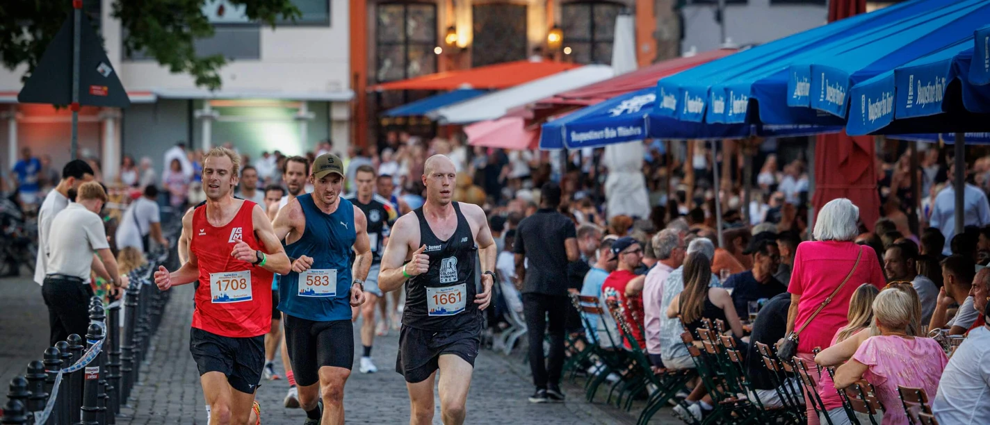 Läufer in Köln Läufer beim Halbmarathon auf Kopfsteinpflaster, Zuschauer am Streckenrand