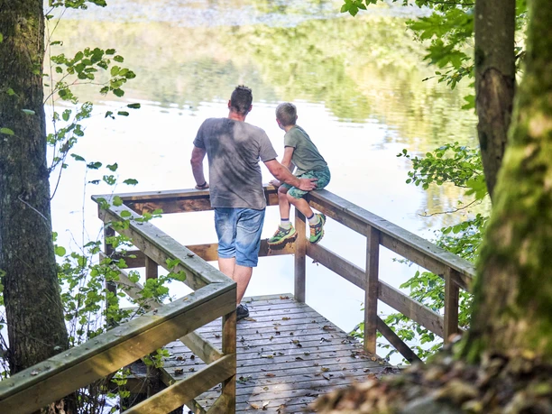 Steg am Schnepfenbachweiher Vater und Sohn schauen vom Steg aus auf den Schnepfenbachweiher