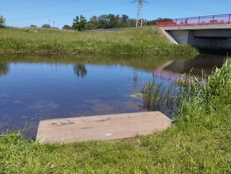 Einsetzstelle K20 Große Aue.jpg Kanu-Einsetzstelle an der Großen Aue mit Holzsteg, Schilfufer und Brücke.