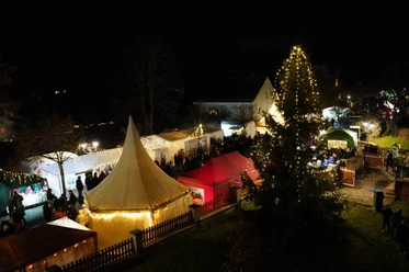 Röthaer Adventsmarkt - Weihnachtsmärkte in der Region Leipzig Buden und Weihnachnachtsbaum auf dem Röthaer Adventsmarkt am Abend