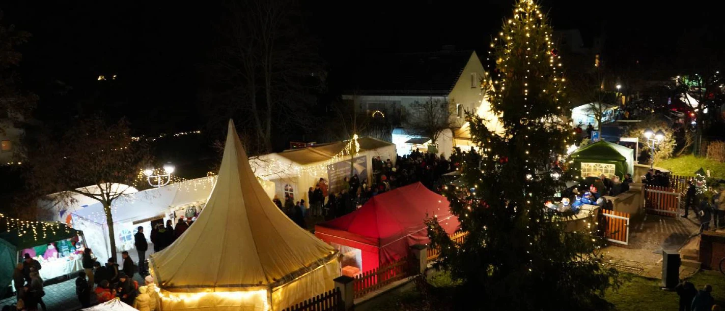 Röthaer Adventsmarkt - Weihnachtsmärkte in der Region Leipzig Buden und Weihnachnachtsbaum auf dem Röthaer Adventsmarkt am Abend