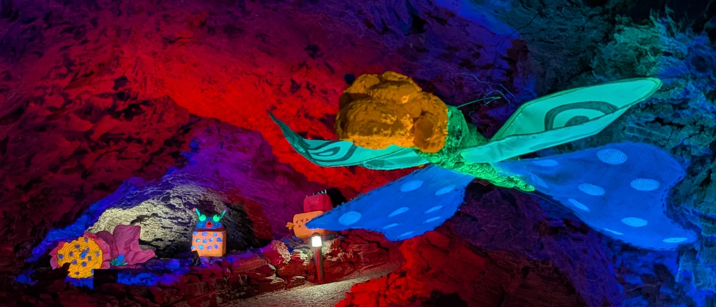 Barbarossahöhle - World of Lights Bunt illuminierter Felsgang der Barbarossahöhle mit großer Schmetterlingsfigur.