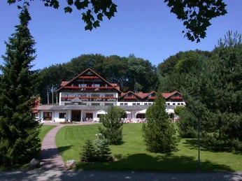 Aussenansicht mit Terrasse im Hotel Mügge am Iberg, Oerlinghausen Hotel Mügge am Iberg mit Terrassenansicht, umgeben von grüner Landschaft und angrenzendem Wald.