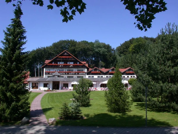 Aussenansicht mit Terrasse im Hotel Mügge am Iberg, Oerlinghausen Hotel Mügge am Iberg mit Terrassenansicht, umgeben von grüner Landschaft und angrenzendem Wald.