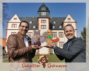 Pressebild_Spuernasen_Salzgitter_HD.jpg Zwei Männer präsentieren Spürnasen-Figuren vor dem Schloss Salder in Salzgitter.