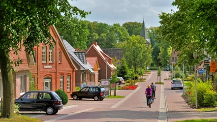 Radfahrer fahren in Richtung der Gangolf-Kirche in Oerel Radfahrer fahren in Richtung der Gangolf-Kirche in Oerel