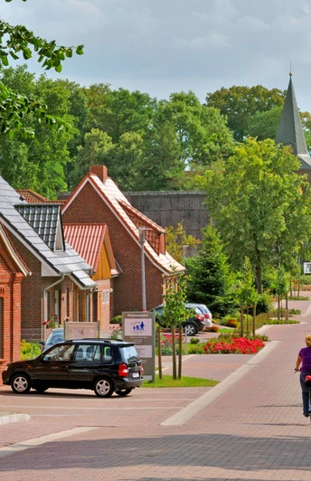 Radfahrer fahren in Richtung der Gangolf-Kirche in Oerel Radfahrer fahren in Richtung der Gangolf-Kirche in Oerel