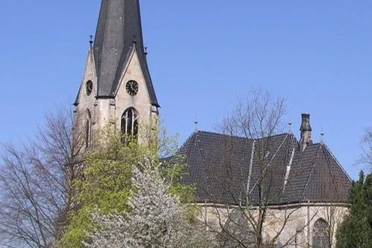 Kirche Kleinenbremen Die evangelische Kirche Kleinenbremen vor blauem Himmel, umgeben von blühenden Bäumen im Frühjahr.