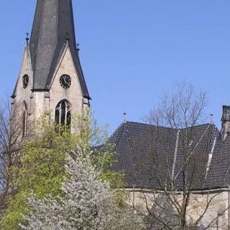 Kirche Kleinenbremen Die evangelische Kirche Kleinenbremen vor blauem Himmel, umgeben von blühenden Bäumen im Frühjahr.