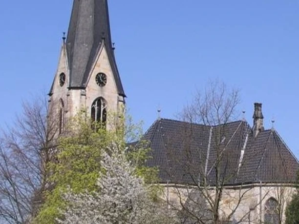 Kirche Kleinenbremen Die evangelische Kirche Kleinenbremen vor blauem Himmel, umgeben von blühenden Bäumen im Frühjahr.