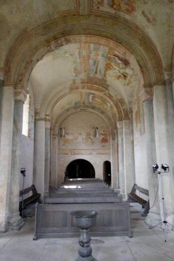 Sigwardskirche von innen Innenraum der Sigwardskirche mit bemalten Gewölben, steinernen Säulen und einem schlichten Taufbecken.
