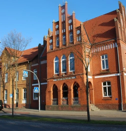 Rathaus Stolzenau Backsteingebäude mit gotischen Fenstern, das Stolzenauer Rathaus; Funkmast im Hintergrund.