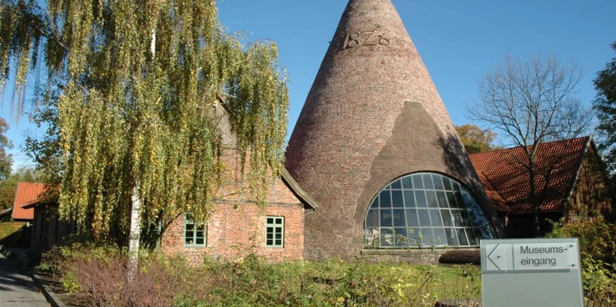 Glashütte Gernheim Historische Glashütte Gernheim mit auffälligem Kegeldach aus Backstein, umgeben von Bäumen.