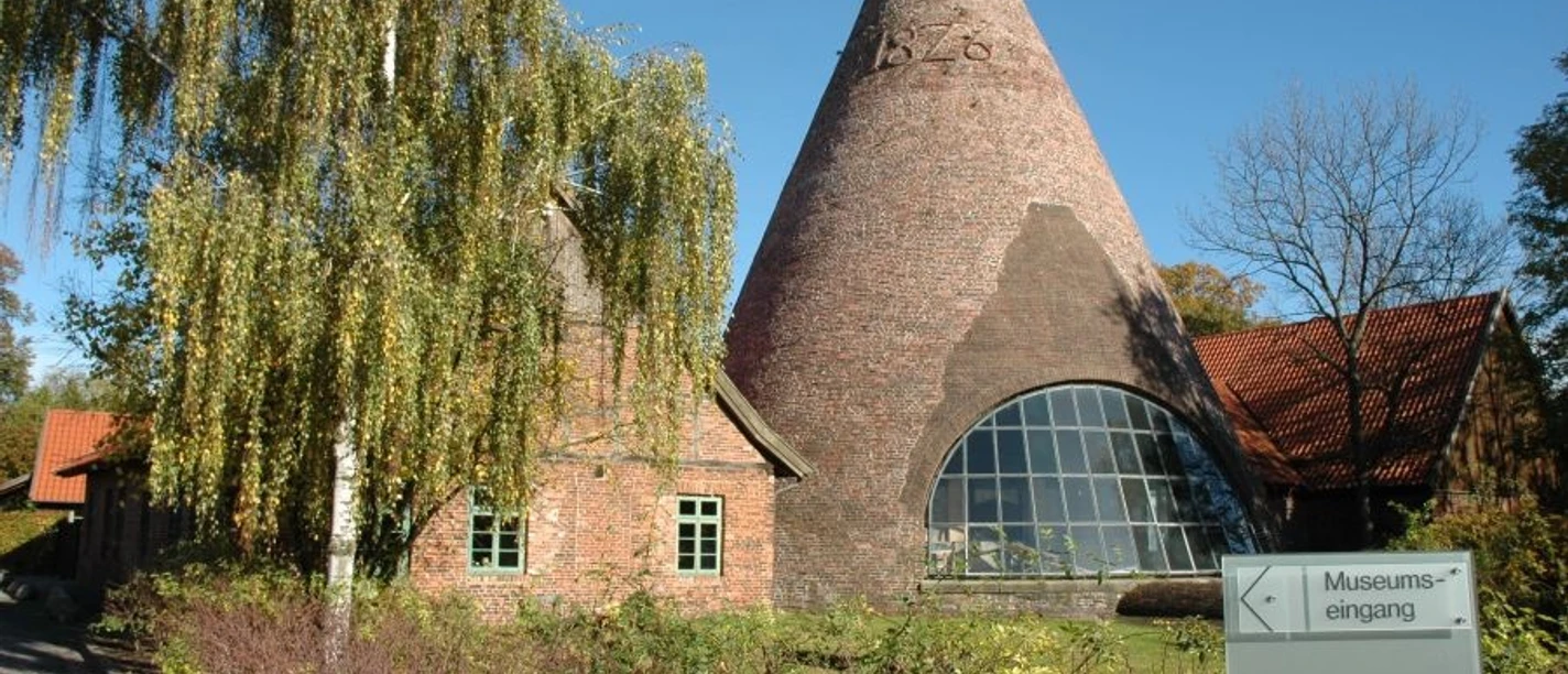 Glashütte Gernheim Historische Glashütte Gernheim mit auffälligem Kegeldach aus Backstein, umgeben von Bäumen.